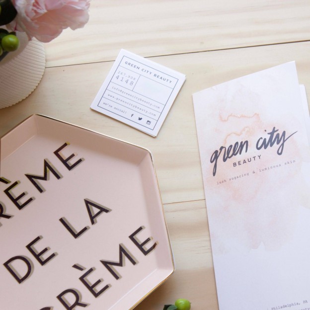 Green City Beauty gift card and branded card displayed on a light wood surface