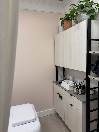 Green City Beauty treatment room with skincare products, cabinet storage, and treatment bed